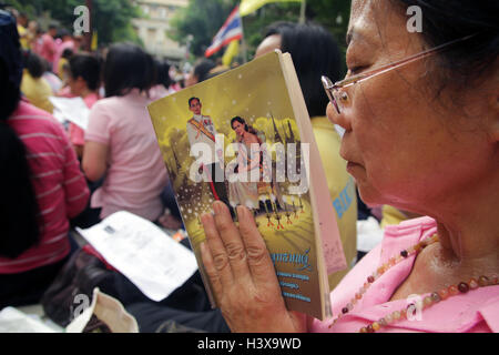 Bangkok, Thailand. 13. Oktober 2016. Eine Frau hält ein Porträt des thailändischen Königs Bhumibol Adulyadej und Königin Sirikit, wie sie auf Gebet nimmt der König Gesundheit am Siriraj Hospital. Thailands König Bhumibol Adulyadej hat verstarb nach langer Krankheit, der Palast am 13. Oktober 2016 Credit: Piti A Sahakorn/Alamy Live News Stockfoto