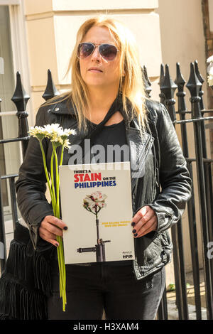 London, UK. 13. Oktober 2016. Eine Frau hält, weißen Blüten und ein Plakat "Gibt es ein Fleck auf den Philippinen" außerhalb der philippinischen Botschaft. Demonstranten haben, liefern einem Brief an den Philippinen Botschafter fordern Präsident Rodrigo Duterte dazu seine wiederholten Aufforderungen für Polizei und öffentliche, jene zu töten, die nutzen und Drogen umzugehen und zurückziehen sein Versprechen, es werden, keine Strafverfolgung für diese außergerichtlichen Hinrichtungen. Da er an die macht Ende Juni kam gab es mehr als 3500 solche Tötungen auf den Straßen. Bildnachweis: Peter Marshall/Alamy Live-Nachrichten Stockfoto