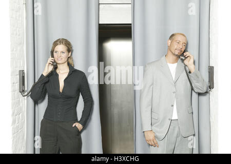 Vorhang, Lift, Geschäftsleute, Wand-Handys aufrufen, halbe Porträt, Frau, Büroangestellte, Manager, Geschäftsfrau, Karrierefrau, Mann, Geschäftsmann, Manager, Büroangestellte, jung, 20-30 Jahre, Kollegen, Kollegen, Partner, Streit, Wettbewerber, Telefone, Empfänger, zwei, Kommunikation, Telekommunikation, Beruf, Geschäft, Bürojob, Wettbewerb, Zugänglichkeit, Service, Informationen, heben Tür, Lift, Tür, eng, geschlossen, in Halle, Stockfoto