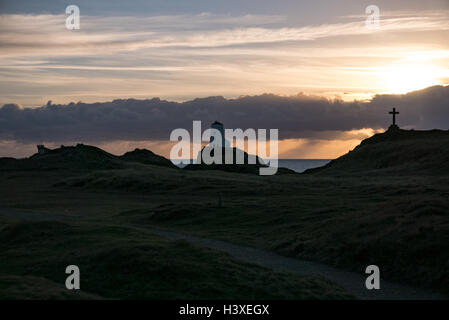 Llanddwyn Leuchtturm in der Nähe von Silhouette gegen einer untergehenden Sonne Stockfoto