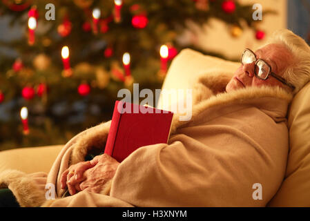 Sitzen, Zimmer, Sofa, Detail, Senior, Decke, gewickelt, Buch, nachdenklich, Weihnachtsbaum, innen, zu Hause, Weihnachten, Yule Flut, für Weihnachten, Heiligabend, Heiligabend, Weihnachtsbaum, Kerzen, brennen, Frau, alt, Rentner, Alter Mensch, alte Männer, alte wom Stockfoto