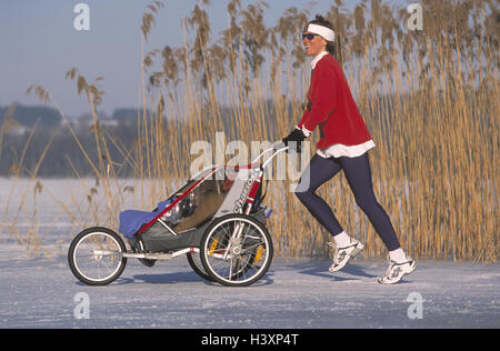 Jogger, Kinderwagen, Winter Frau, Mutter, 36 Jahre, Baby Jogger, Joggen, Joggen, Freizeit, Hobby, Sport, Aktivität, Fitness, Freude leben, Freizeit Zeit Equalizer, Gesundheit, Schnee, See, Serie See, Murnau, Oberbayern, Deutschland, 30-40 Jahre Stockfoto