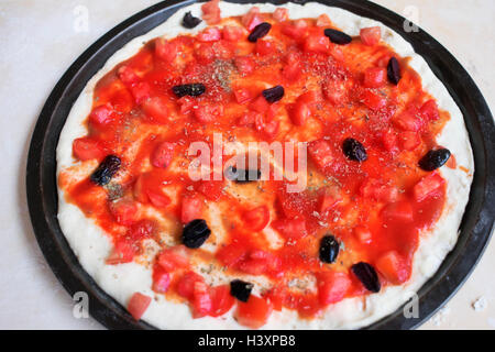 Pizza mit frischen gehackten Tomaten und schwarzen Oliven genannt Pizza marinara Stockfoto