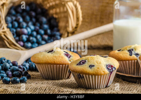 Blueberry Muffins Milch und Marmelade im Hintergrund und Korb voll mit Heidelbeeren Stockfoto