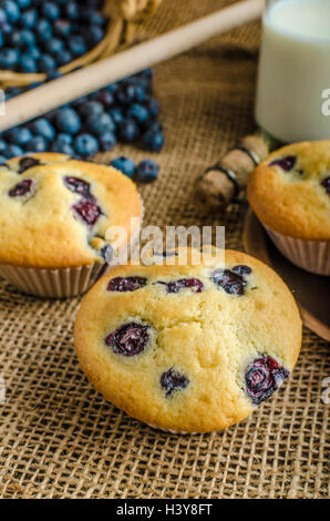 Blueberry Muffins Milch und Marmelade im Hintergrund und Korb voll mit Heidelbeeren Stockfoto