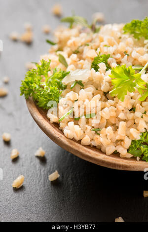 Bulgur mit frischen Kräutern in Nahaufnahme. Frische und gesunde vegetarische oder vegane Speisen. Stockfoto