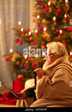 Sitzen, Zimmer, Sofa, Senior, Decke, gewickelt, Stock, Fotografie, aussehen, innen, zu Hause, Weihnachten, Yule Flut, für Weihnachten, Heiligabend, Heiligabend, Weihnachtsbaum, Kerzen, Verbrennungen, Frau, alt, Rentner, Alter Mensch, alte Männer, alte Frau, nur, lonel Stockfoto