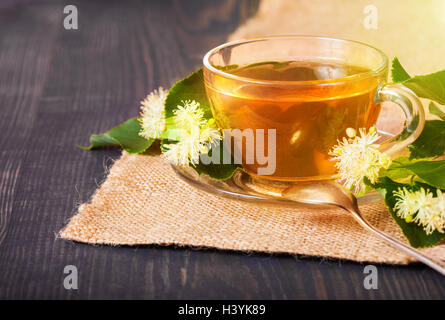 Linden Tee auf einem Holztisch in eine Glasschale. Blumentee, Kräutermedizin. Stockfoto