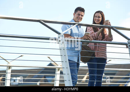 Porträt des jungen Paares zu Fuß zur Arbeit über Brücke Stockfoto