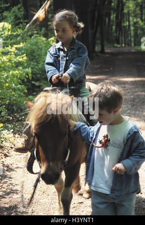 Waldweg, Kinder, Pony, Reiten Holz Weg, junge, Mädchen, Freunde, Freundschaft, Geschwister, Pony-reiten, Reiten, ausreiten, Tierliebe, Hobby, Freizeit, Pferd, kleines Pferd, Kindheit, Kindheitserlebnis Stockfoto