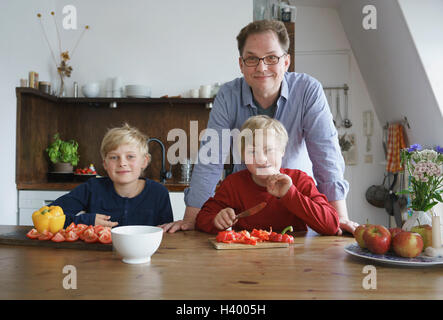 Porträt der Vater mit Söhnen sitzen am Tisch in der Küche Stockfoto