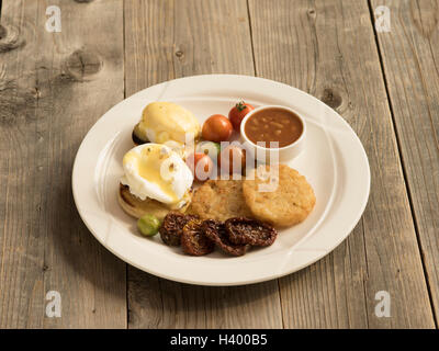 Kontinentales Frühstück - Eier benedict mit verschiedenen Sachen, Tomaten und Hollandaise Stockfoto