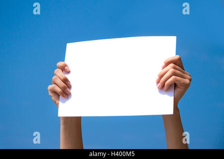 Person, die eine leere Seite in seinen Händen mit blauem Himmelshintergrund Stockfoto