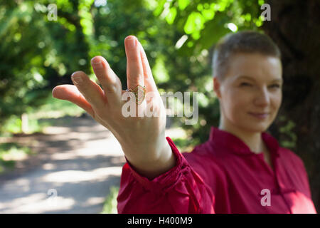 Frau trägt Ring gestikulieren beim Üben von Tai Chi im park Stockfoto