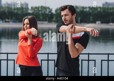 Strecken Arme durch Geländer neben See Freunde Stockfoto