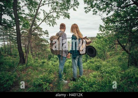 Rückansicht des paar Hand in Hand beim Wandern im Wald Stockfoto