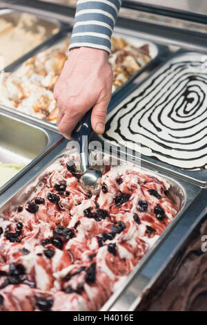 Detail von Hand schöpfen Eis aus Container im store Stockfoto