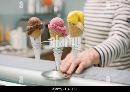 Mittelteil des Menschen durch verschiedene Eistüten in Stand im store Stockfoto