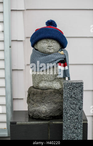 Ksitigarbha Statue auf Sockel gegen Wand Stockfoto