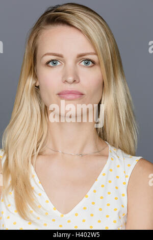 Portrait der schönen Frau stand vor grauem Hintergrund Stockfoto