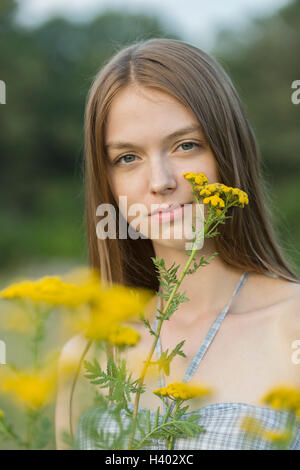 Portrait der schönen Frau mit gelben Blüten im park Stockfoto