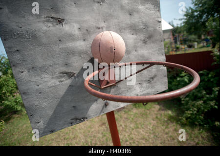 alten Basketball und Korb auf verwitterte Holzfassade Stockfoto