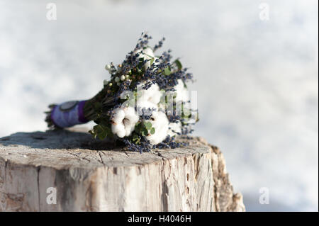 Schöne Hochzeit Brautstrauß auf einem Baumstumpf aus Baumwolle und blaue Blüten Stockfoto