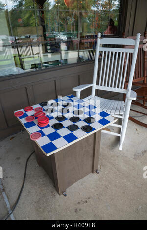 Riesige Checker mit Schaukelstühlen vor einem Cracker Barrel Restaurant gesetzt. Stockfoto