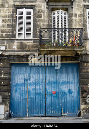 Eine französische blaue Garagentor mit "Parke nicht" anmelden Französisch, unter typischen französischen Fensterläden. Stockfoto