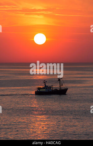 Ein Fischkutter in der Nordsee vor der Küste von Belgien bei Sonnenuntergang. Stockfoto