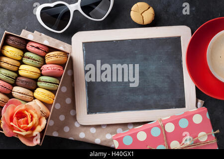 Bunte Makronen, Kaffee und Tafel. Süßen Macarons in Geschenk-Box am Steintisch. Draufsicht mit Textfreiraum Stockfoto