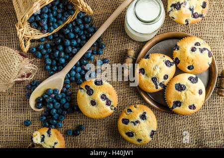 Blueberry Muffins Milch und Marmelade im Hintergrund und Korb voll mit Heidelbeeren Stockfoto