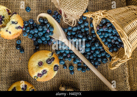 Blueberry Muffins Milch und Marmelade im Hintergrund und Korb voll mit Heidelbeeren Stockfoto