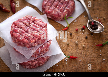 Rohen Boden Rindfleisch Burger Frikadellen an Picknick-Tisch Stockfoto
