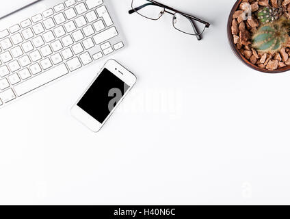 Weiße Tastatur mit Brille und Telefon und Kaktus auf weißem Hintergrund Stockfoto