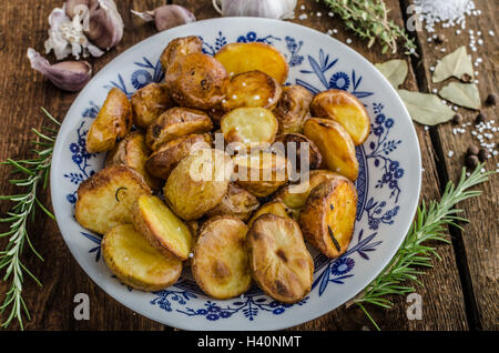 Gebackene Kartoffeln mit Kräutern und Knoblauch im Ofen Stockfoto