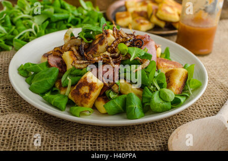 Kartoffel-Gnocchi mit Sommer-Salat, Speck und Röstzwiebeln. Gnocchi gekocht und dann auf Pfanne für Golden knusprig gebraten Stockfoto