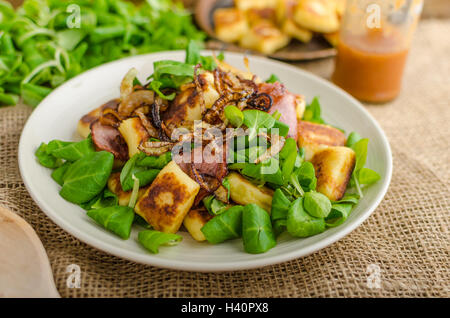 Kartoffel-Gnocchi mit Sommer-Salat, Speck und Röstzwiebeln. Gnocchi gekocht und dann auf Pfanne für Golden knusprig gebraten Stockfoto