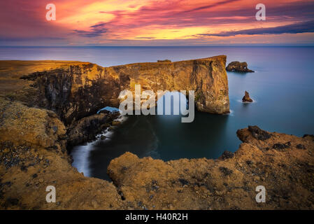 Sonnenuntergang auf Dyrhólaey Arch in Island. Stockfoto