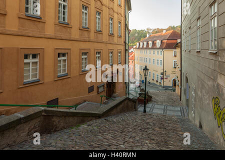 Herbstmorgen auf einer gepflasterten Straße in Mala Strana (Kleinseite) in Prag, Tschechien. Stockfoto