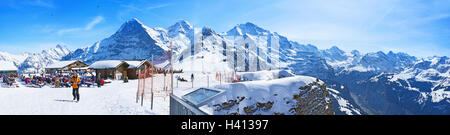 Die Touristen entspannen auf den Sonnenliegen neben Sport-Geräte-Verleih-Station an der Spitze des männlichen in Grindelwald. Stockfoto