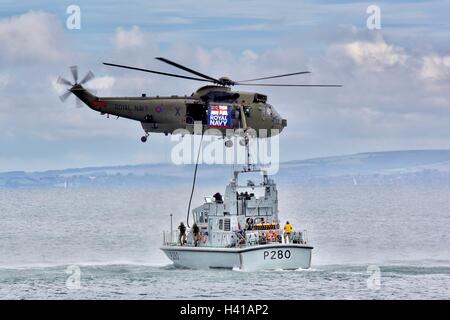 Die Royal Navy Sea King Mk 7 Hubschrauber demonstrieren Truppen boarding ein Piratenschiff in Bournemouth Air Festival. Stockfoto