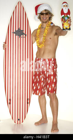 Surfer, 20-30 Jahre, oberen Teil des Körpers, Show-Mann, jung, Shorts, Surfbrett, Nikolausmütze, Schokolade Nicholas frei, Blume Catena, Blume Catena, Sonnenbrille, barfuß, Surfbrett, Schokoladen Weihnachtsmann, süße, Show, Angebot, lachen, glücklich, Icon, va Stockfoto