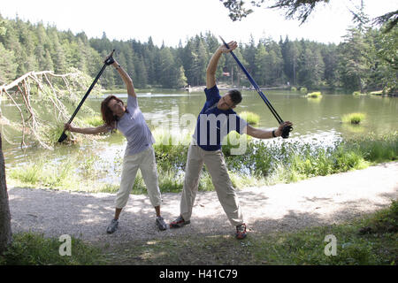 Waldweg, am See, paar, sportlich, Nordic Walking, stretching, zusammen, Sportlerin, Sportler, Sport, Fitness, Fit, Ausdauer-Sport, Trendsport, Sport, aktiv, Sport-Kleidung, Sportbekleidung, Fußböden, Bewegung, Freizeit, Hobby, Sommer, draußen, Stockfoto