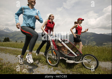 Feldweg, Frauen, Mädchen, sportlich, Joggen, schieben, Baby Jogger, jung, Freunde, Tochter, Säuglinge, Kinderwagen, Sport, Sportlerinnen, Joggen, laufen, laufen, Ausdauer, Ausdauer Sport, Ausdauer training, Training, Fitness-Training, Sport-Bekleidung Stockfoto