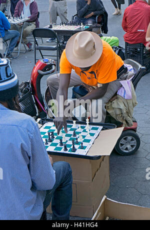 Ein Mann in einem motorisierten Rollstuhl beim Schachspiel im Union Square Park in Manhattan, New York City Stockfoto