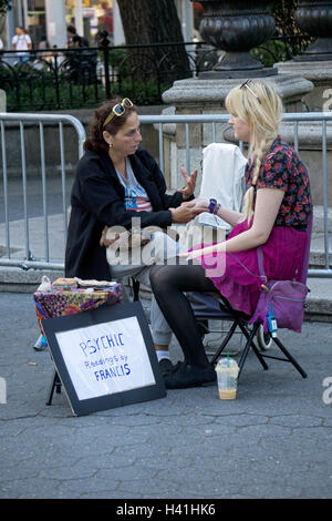 Eine Frau, die einen psychischen Messwert Handlesen in Union Square Park in Manhattan, New York City zu geben. Stockfoto