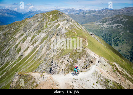 Frau-Mountainbiken in Schweizer Alpen in der Nähe von Davos, Graubünden, Schweiz Stockfoto