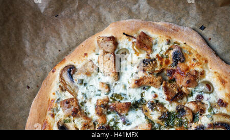 Pizza mit Huhn, Champignons, Oliven, roten Zwiebeln, Petersilie und weiße cremige Sauce. Stockfoto