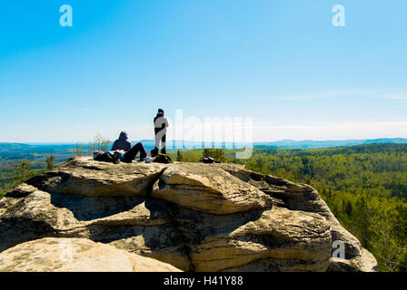 Kaukasische Freunde sitzen auf Berg Felsen bewundern Sie malerische Aussicht Stockfoto